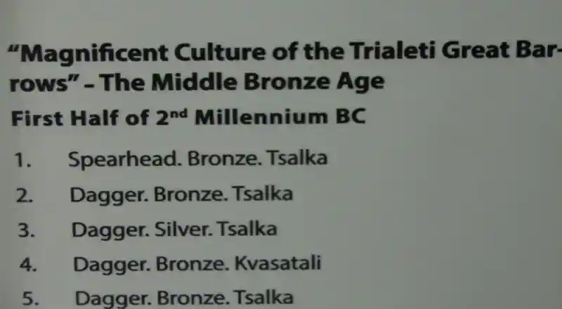 A cross made up of dots on a metal situla